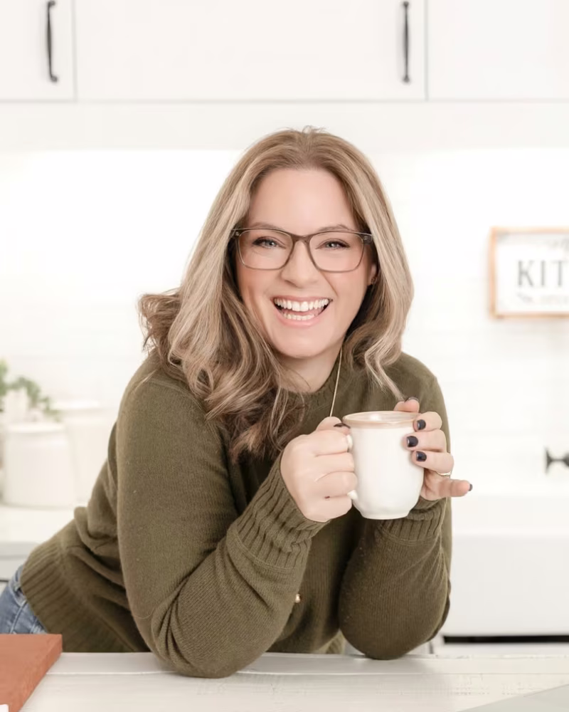 Laura McBride, trusted Ajax REALTOR&reg;, smiling with a coffee in a bright kitchen