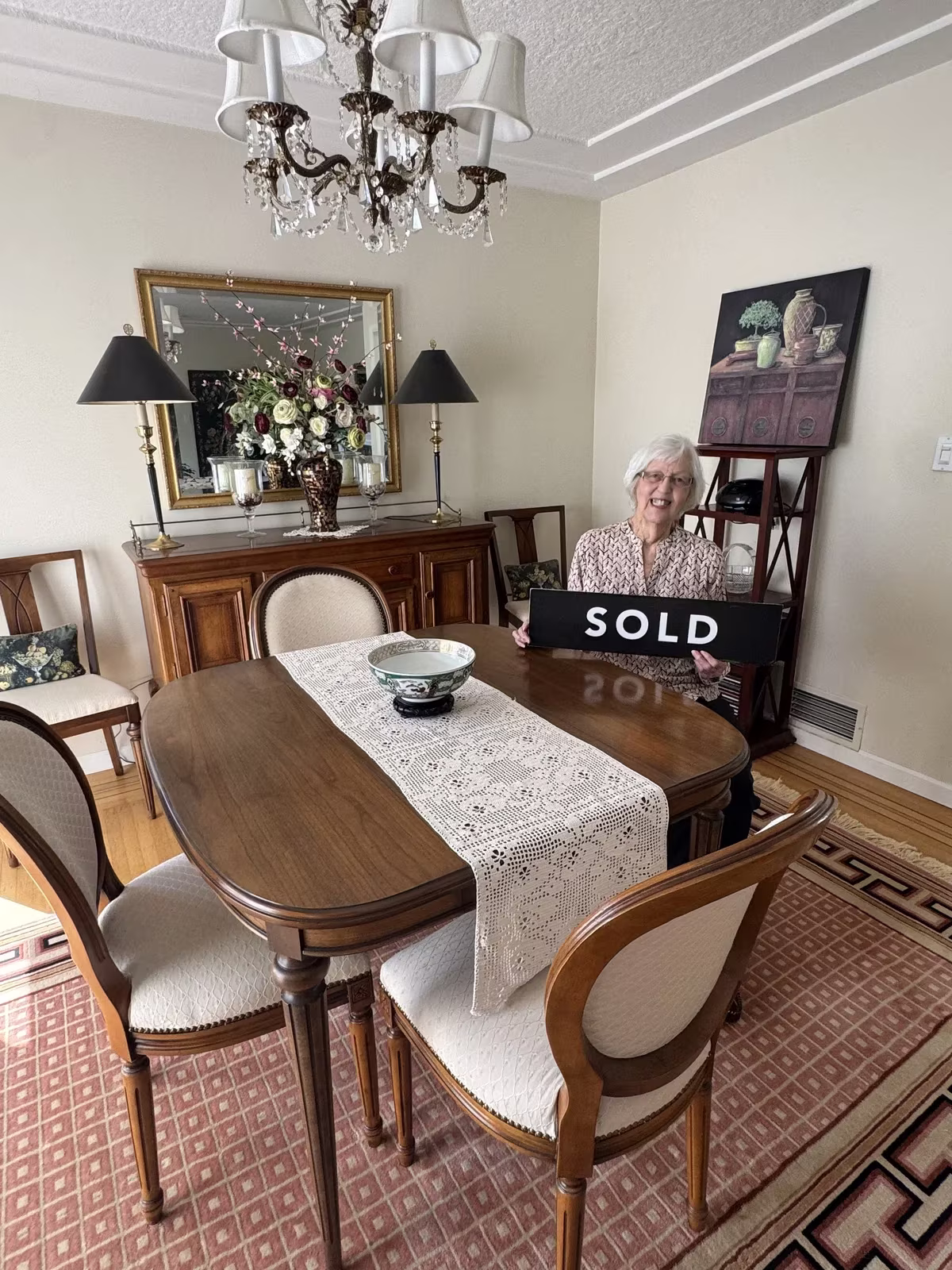 A client's aunt in Vancouver celebrating with a SOLD sign after downsizing her 40-year home before relocating to Durham Region
