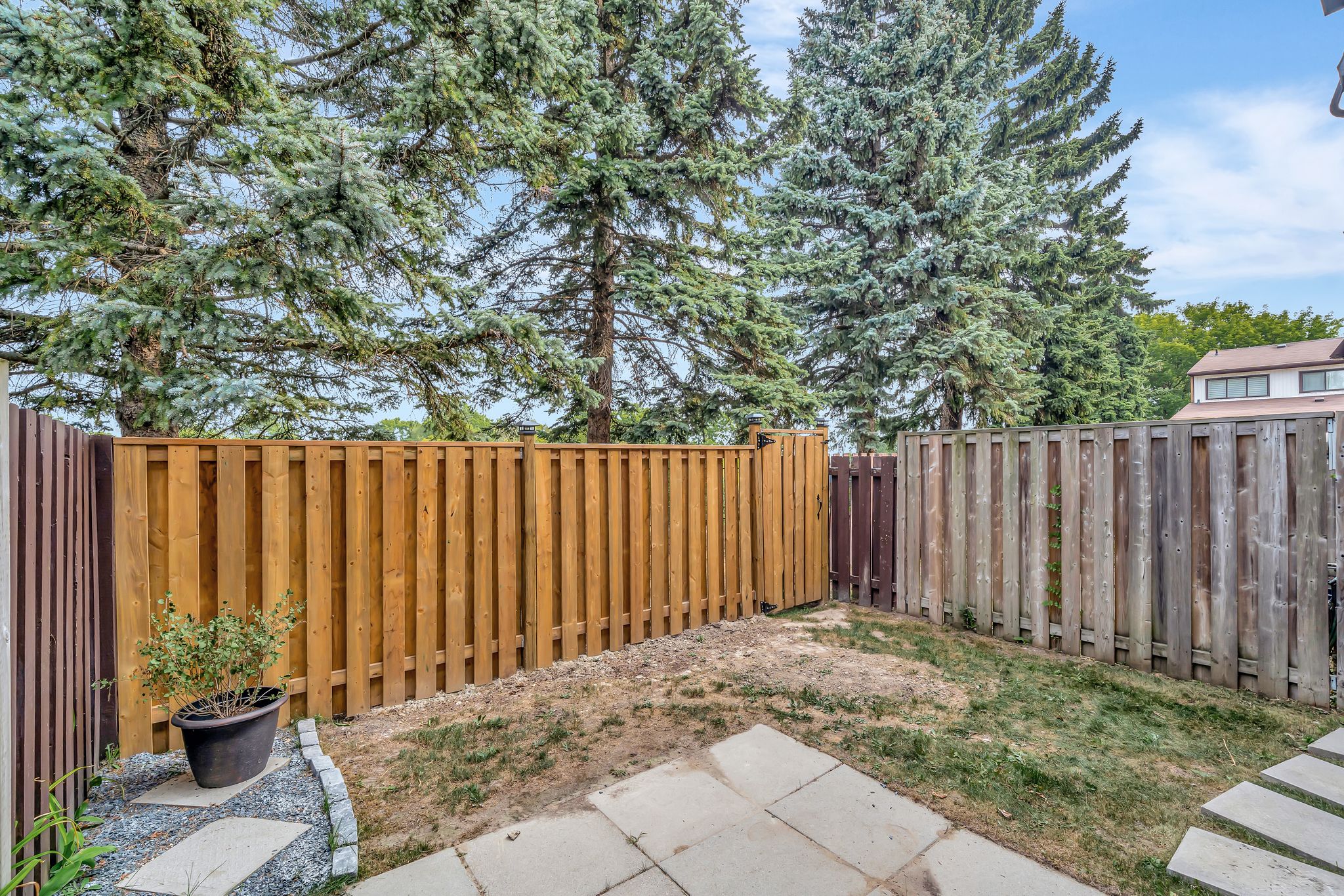 Fenced yard at 10-765 Oklahoma Dr, Pickering, with mature landscaping