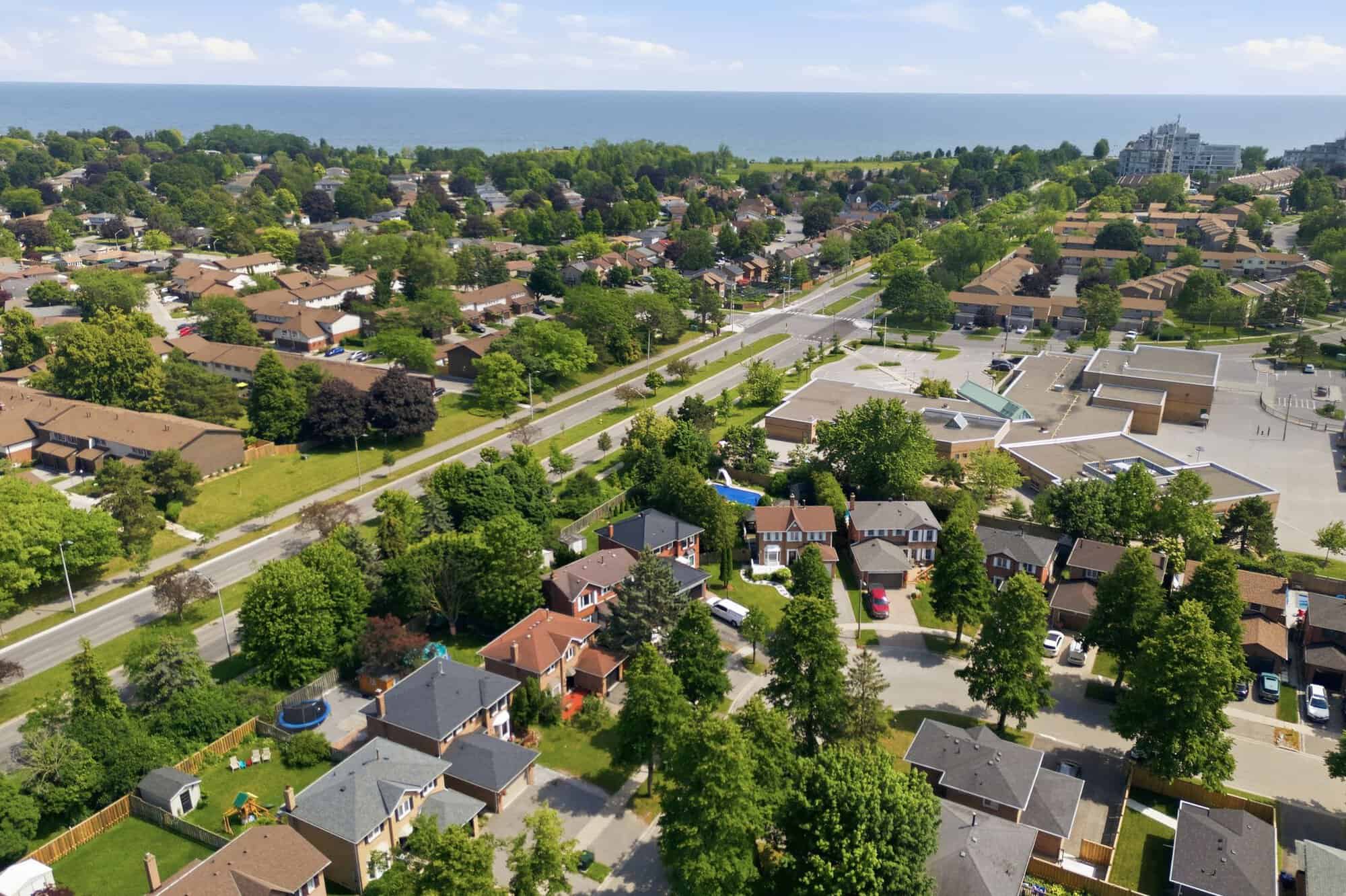 Aerial view of the South Ajax neighbourhood surrounding 13 Flowers Crescent, with nearby homes, green space and Lake Ontario in the distance
