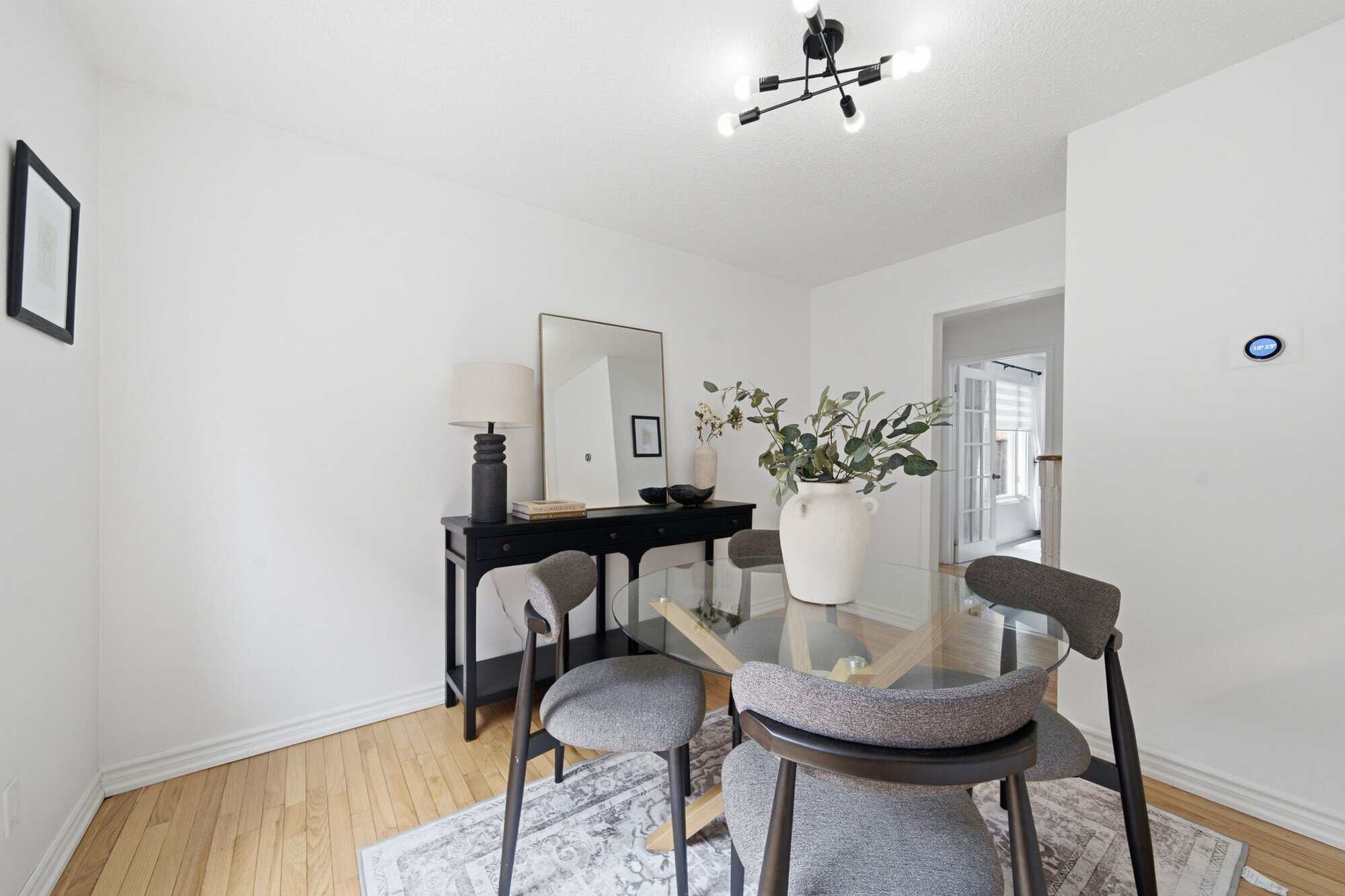 Dining room at 13 Flowers Crescent, South Ajax, with a round glass table, four upholstered chairs and hardwood floors