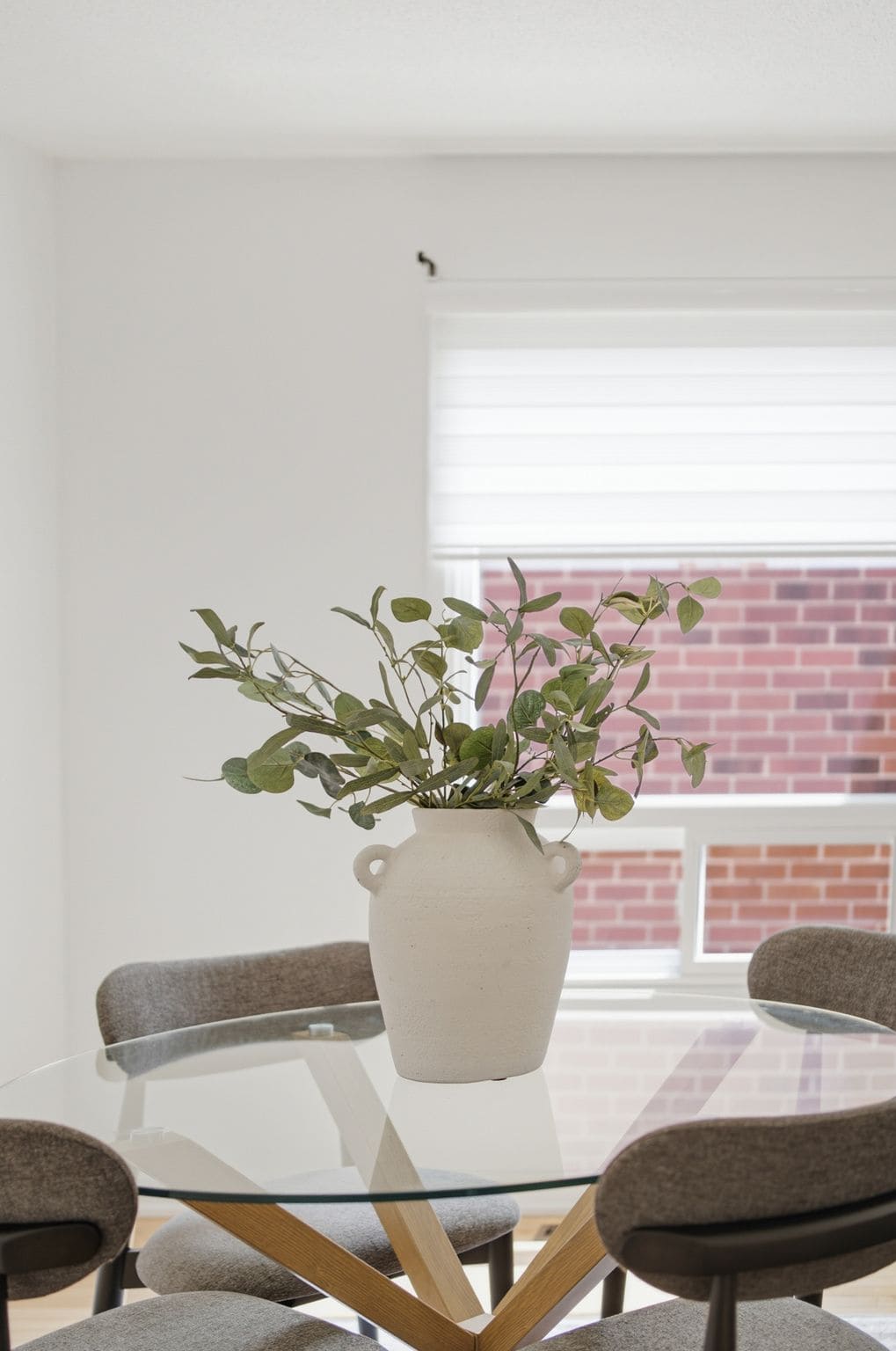 Dining table detail at 13 Flowers Crescent, South Ajax, with a ceramic vase and greenery centrepiece