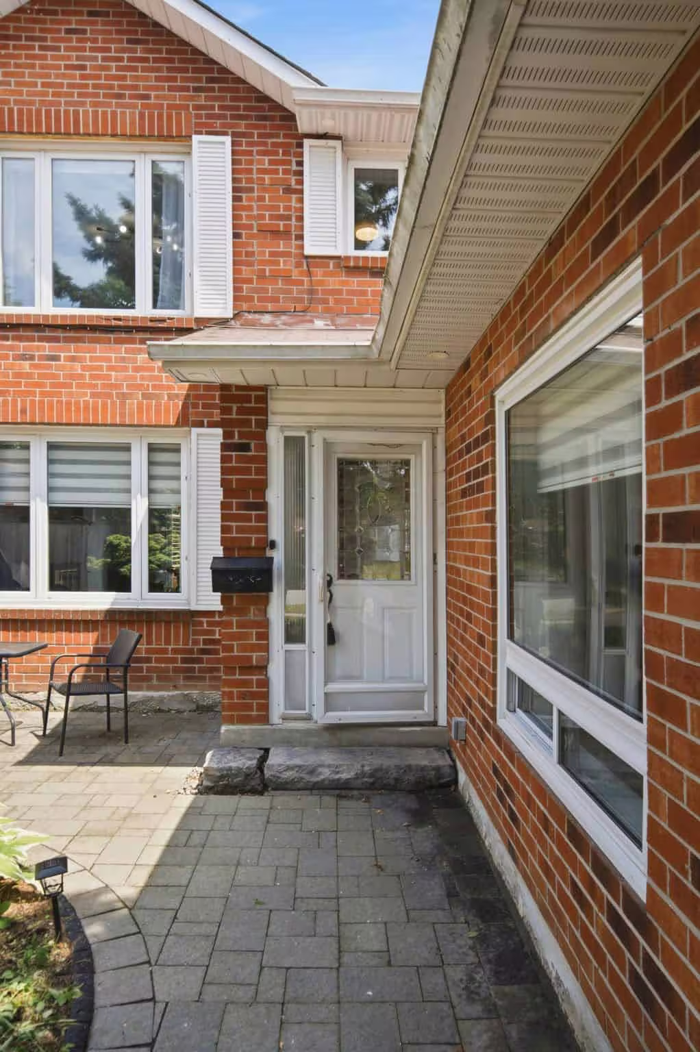 Paved walkway leading to the front entrance of 13 Flowers Crescent, South Ajax, framed by red-brick exterior walls