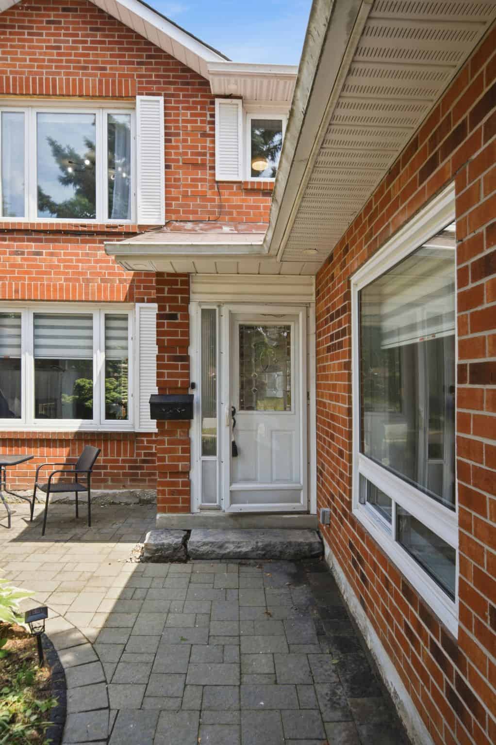 Paved walkway leading to the front entrance of 13 Flowers Crescent, South Ajax, framed by red-brick exterior walls