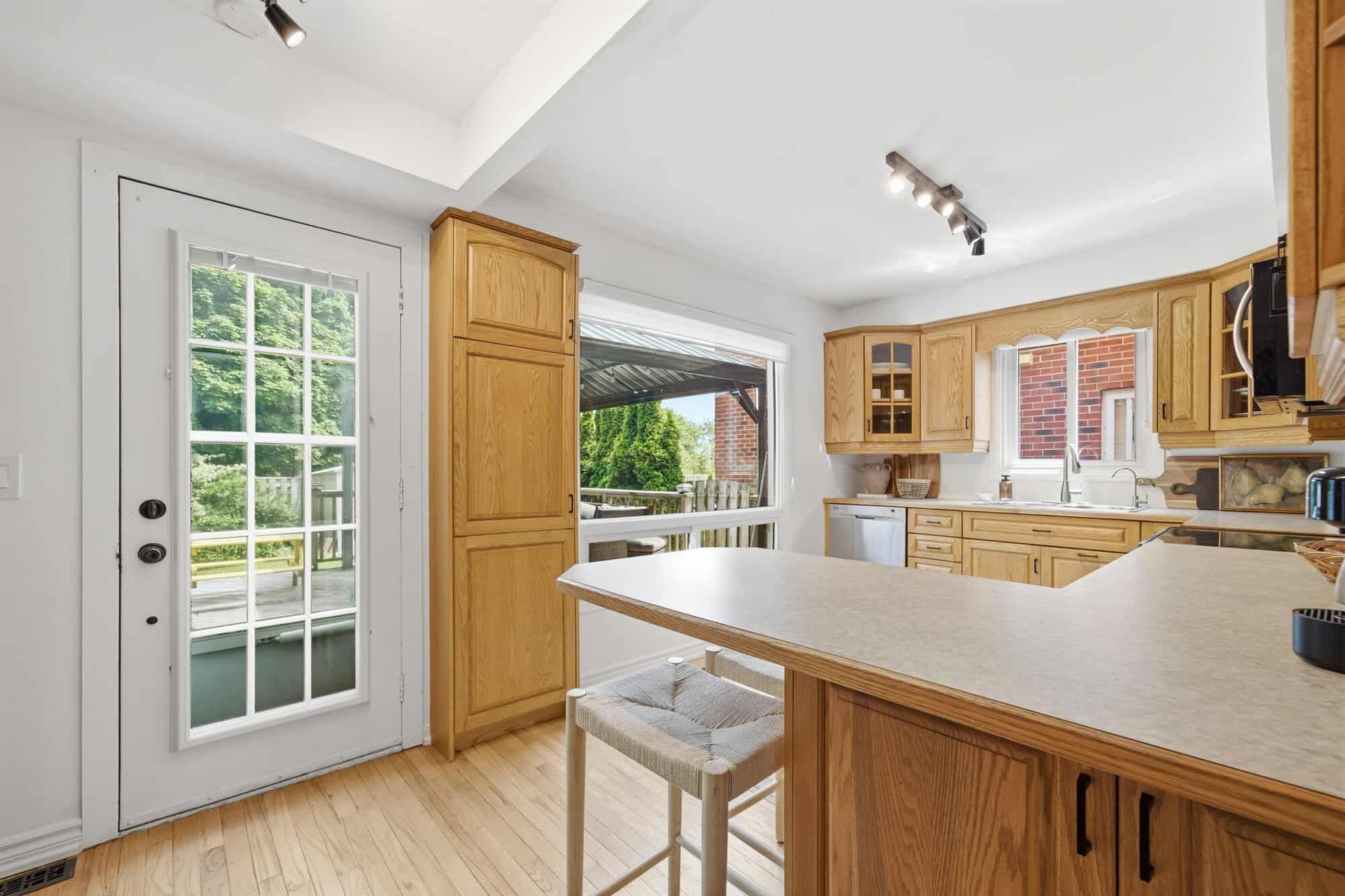 Kitchen at 13 Flowers Crescent, South Ajax, with oak cabinetry, breakfast bar and hardwood floors