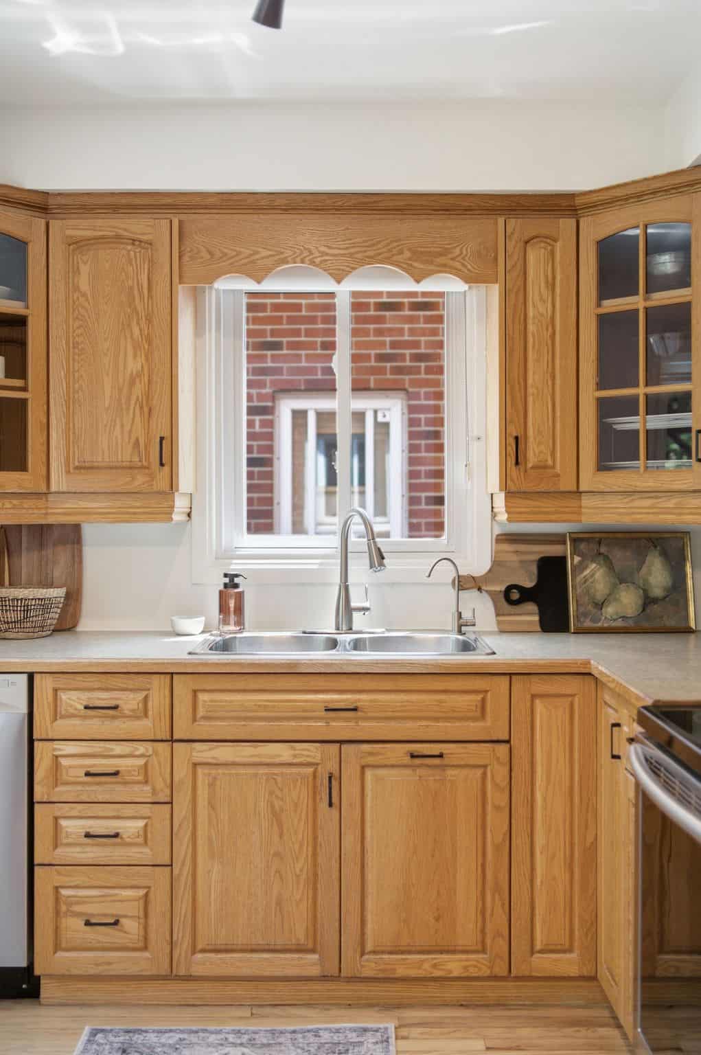 Kitchen sink at 13 Flowers Crescent, South Ajax, with oak cabinetry, a double stainless steel sink and a window above the counter