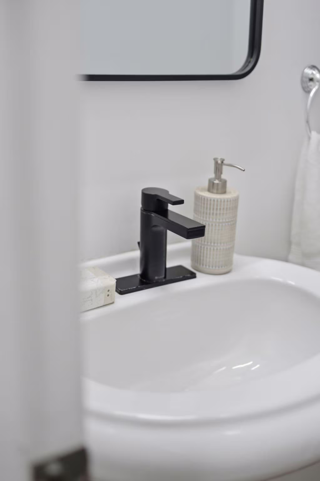 2-piece bathroom attached to the main-floor bedroom suite at 13 Flowers Crescent, South Ajax, with a pedestal sink and black fixtures