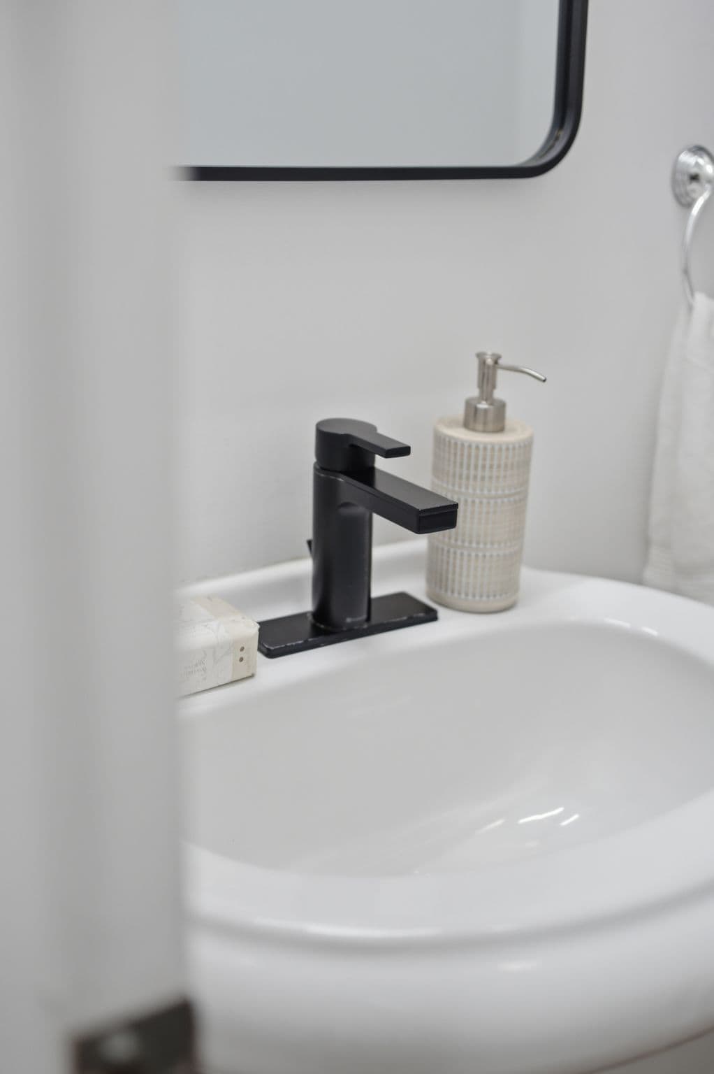 2-piece bathroom attached to the main-floor bedroom suite at 13 Flowers Crescent, South Ajax, with a pedestal sink and black fixtures