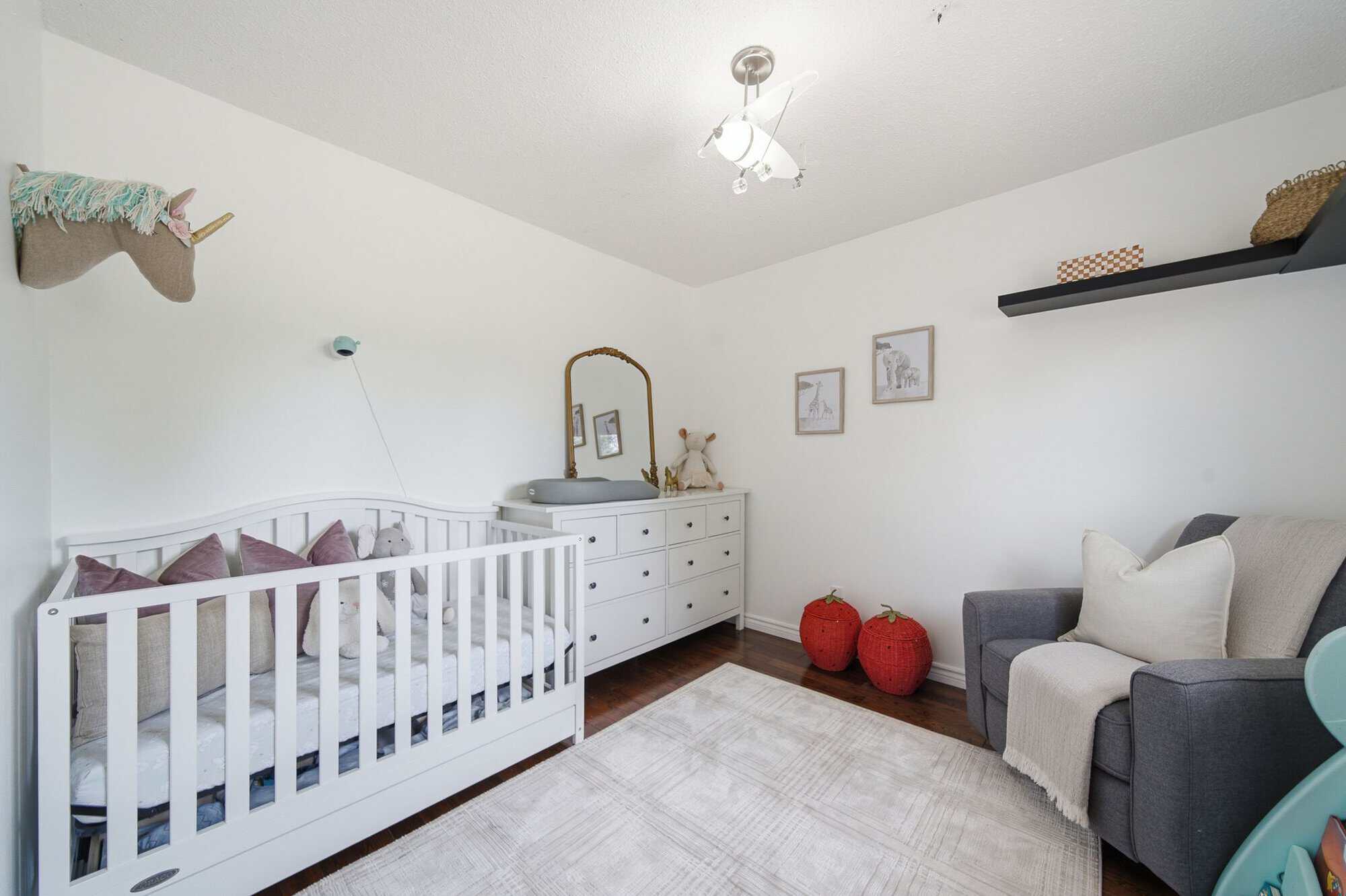 Third bedroom at 13 Flowers Crescent, South Ajax, virtually staged as a bright nursery with a white crib and grey armchair