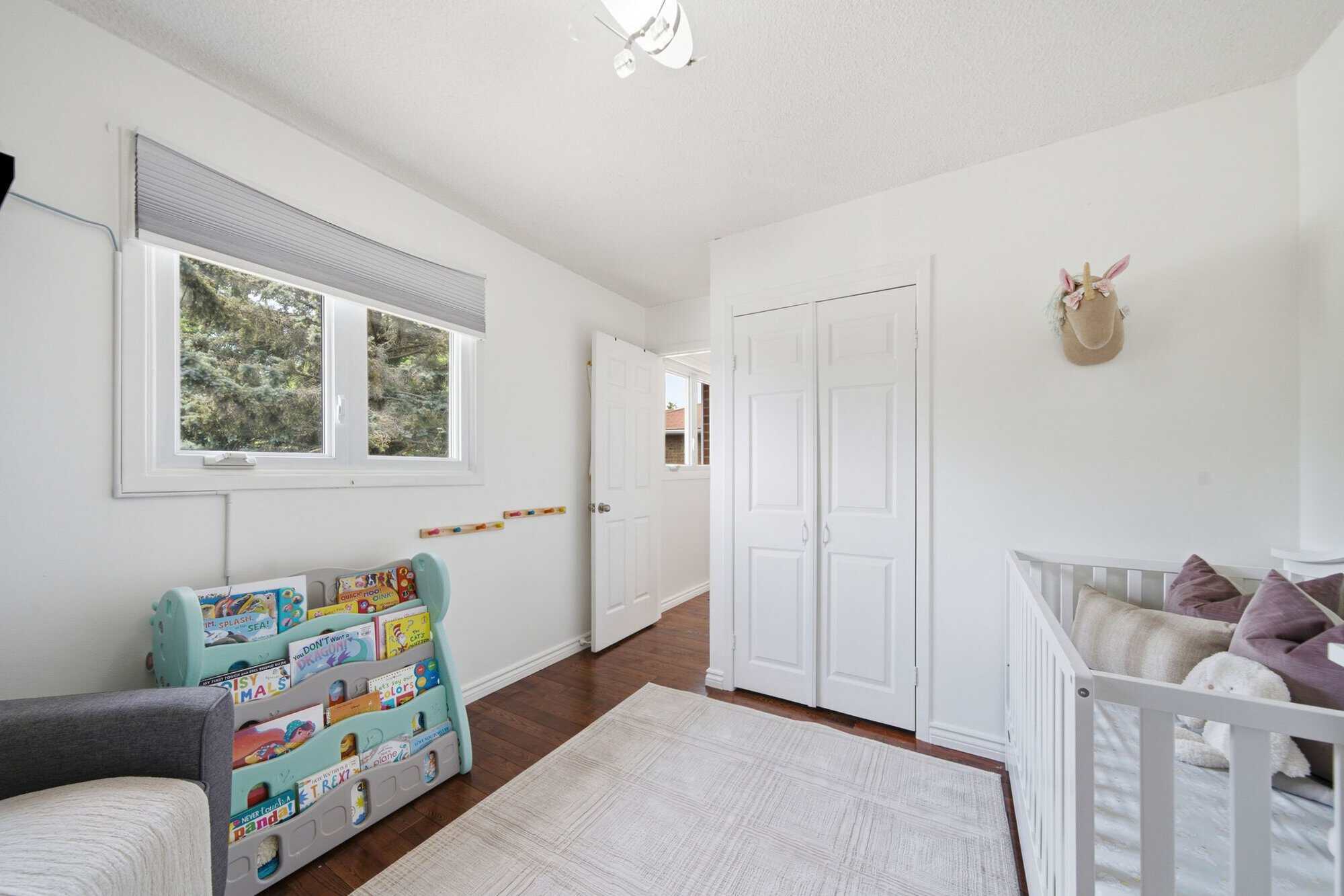 Nursery-staged third bedroom at 13 Flowers Crescent, South Ajax, with a large window and hardwood floors