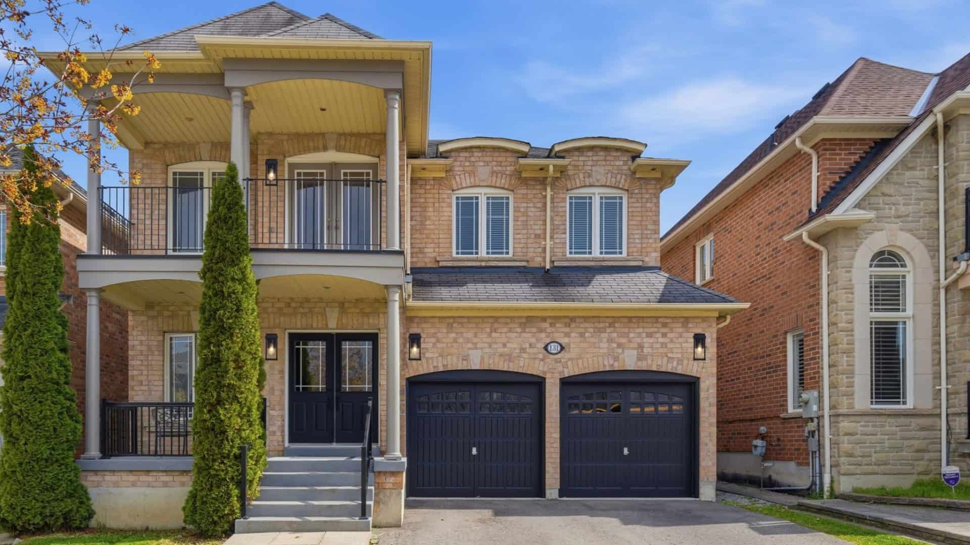 Exterior of 131 Rushworth Drive, Ajax, with brick facade, covered porch, upper balcony and double garage, listed by Laura McBride, Ajax REALTOR® with Revel Realty