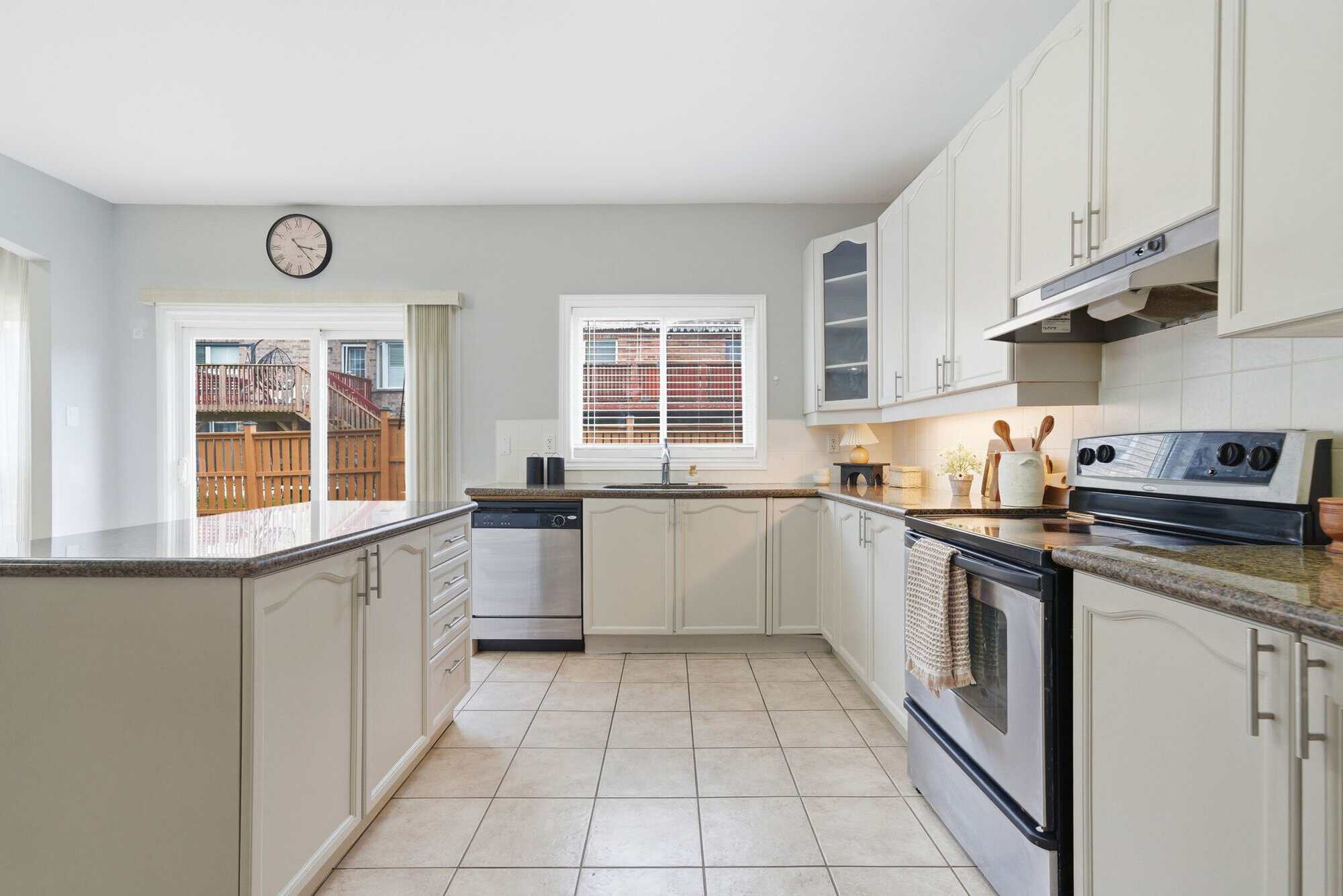 Kitchen at 131 Rushworth Drive, Ajax, with white cabinetry, granite counters and stainless steel appliances