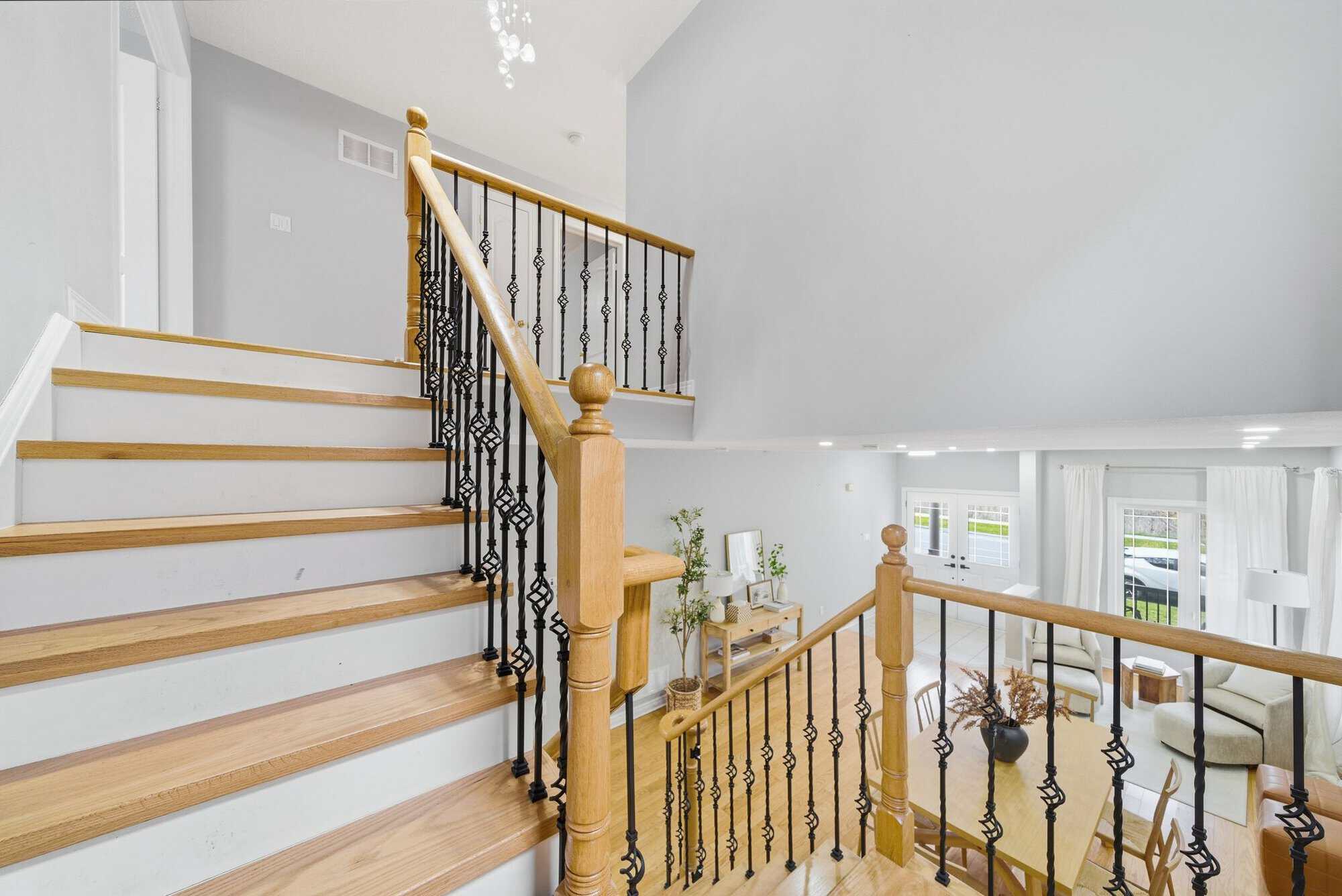 Upper landing staircase at 131 Rushworth Drive, Ajax, with oak treads, white risers and wrought iron spindles