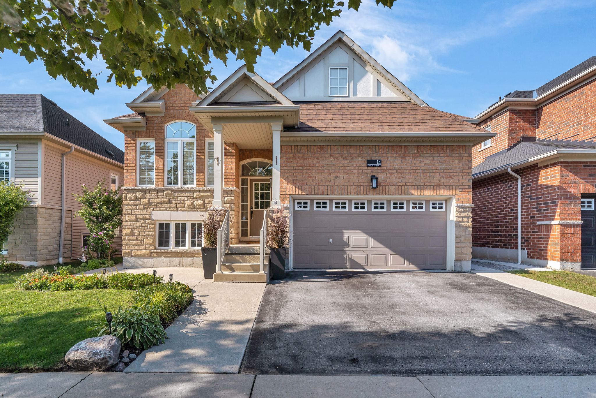 Curb appeal at 14 Sleepy Hollow Place, Whitby, a brick and stone bungalow with a covered porch, double garage and private double driveway
