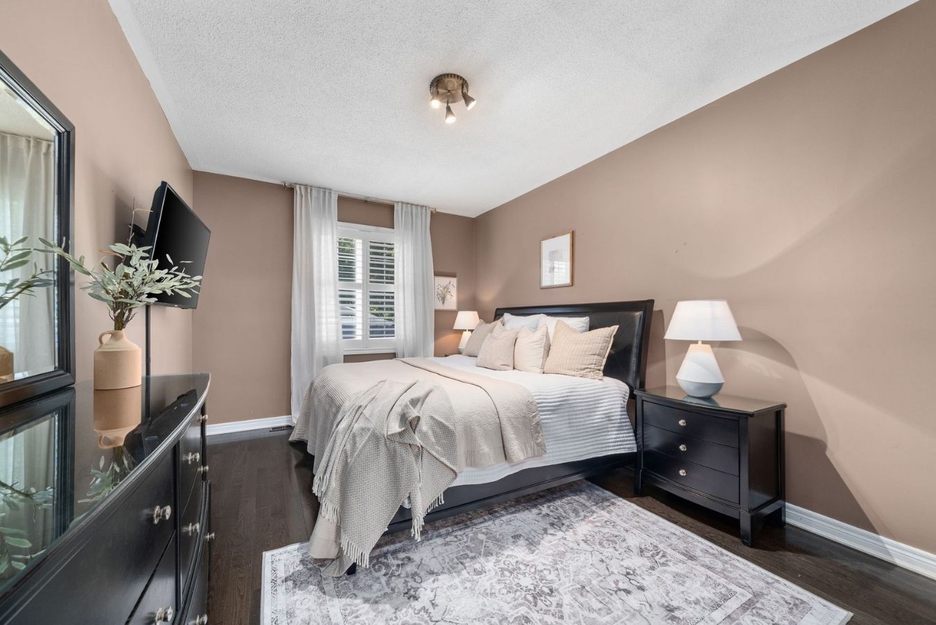 Primary bedroom at 14 Sleepy Hollow Place, Whitby, with a mounted television and dresser