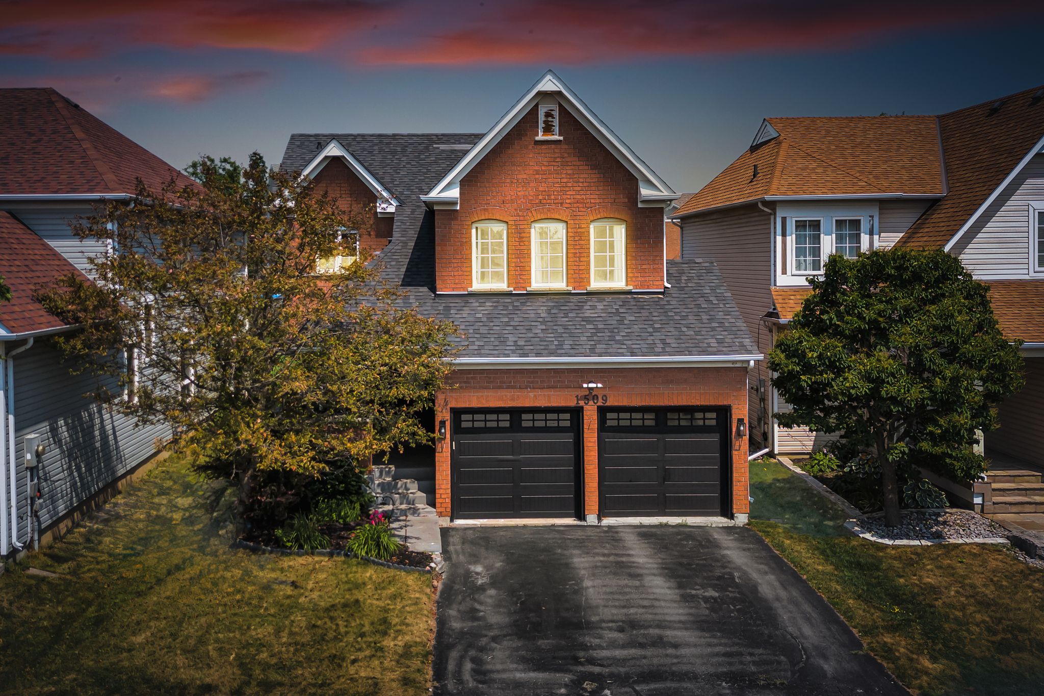 Exterior of 1509 Grandview Street North, Oshawa, a brick two-storey detached home with an attached double garage, sold by Laura McBride, Ajax REALTOR® with Revel Realty