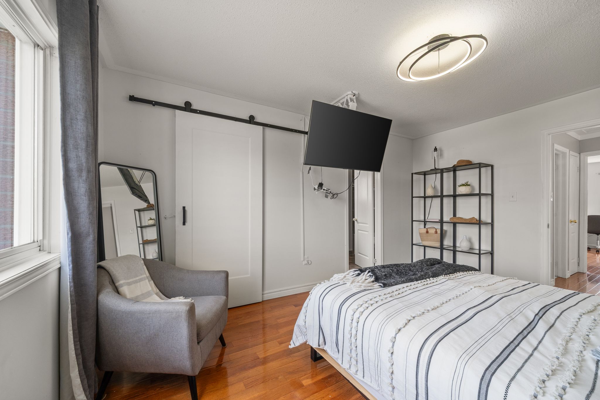 Primary bedroom at 1509 Grandview Street North, Oshawa, with a mounted television and seating
