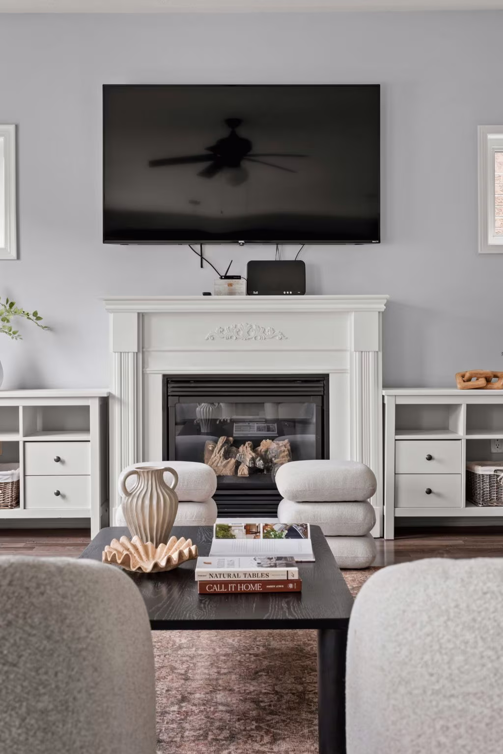 Family room fireplace seating detail at 1683 Finkle Drive, Oshawa, with stacked pouf ottomans and a coffee table