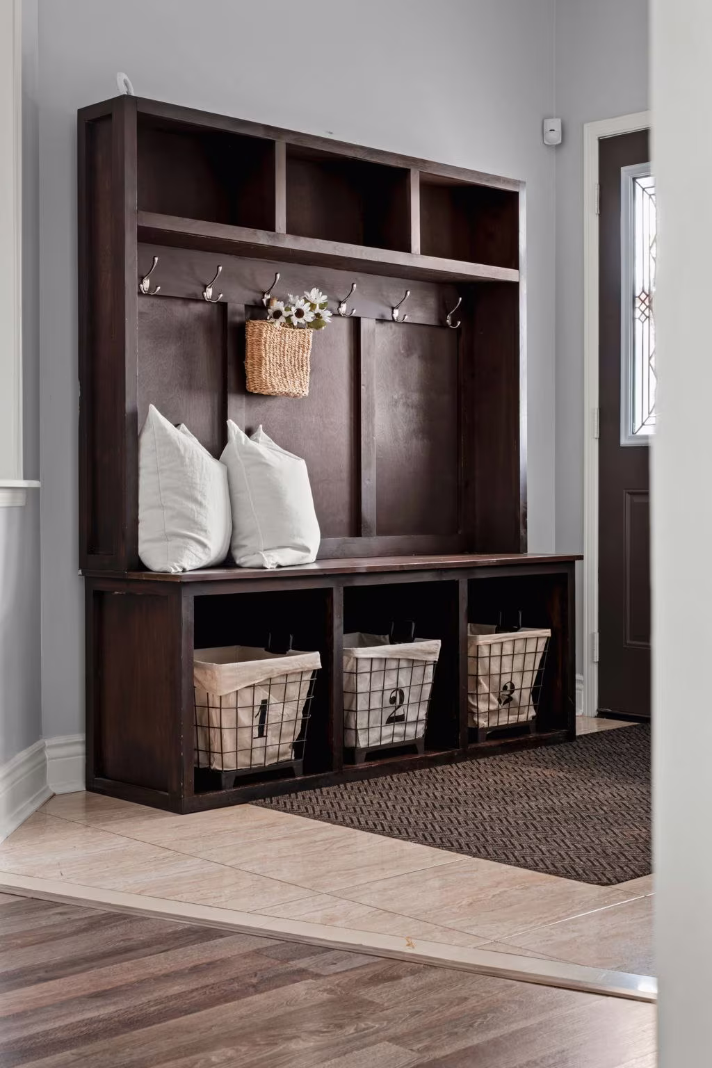 Foyer bench styling detail at 1683 Finkle Drive, Oshawa, with layered pillows and woven storage baskets