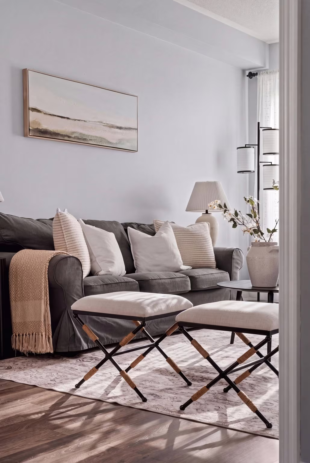 Sunlit living room styling detail at 1683 Finkle Drive, Oshawa, with a gray sofa and X-frame ottomans