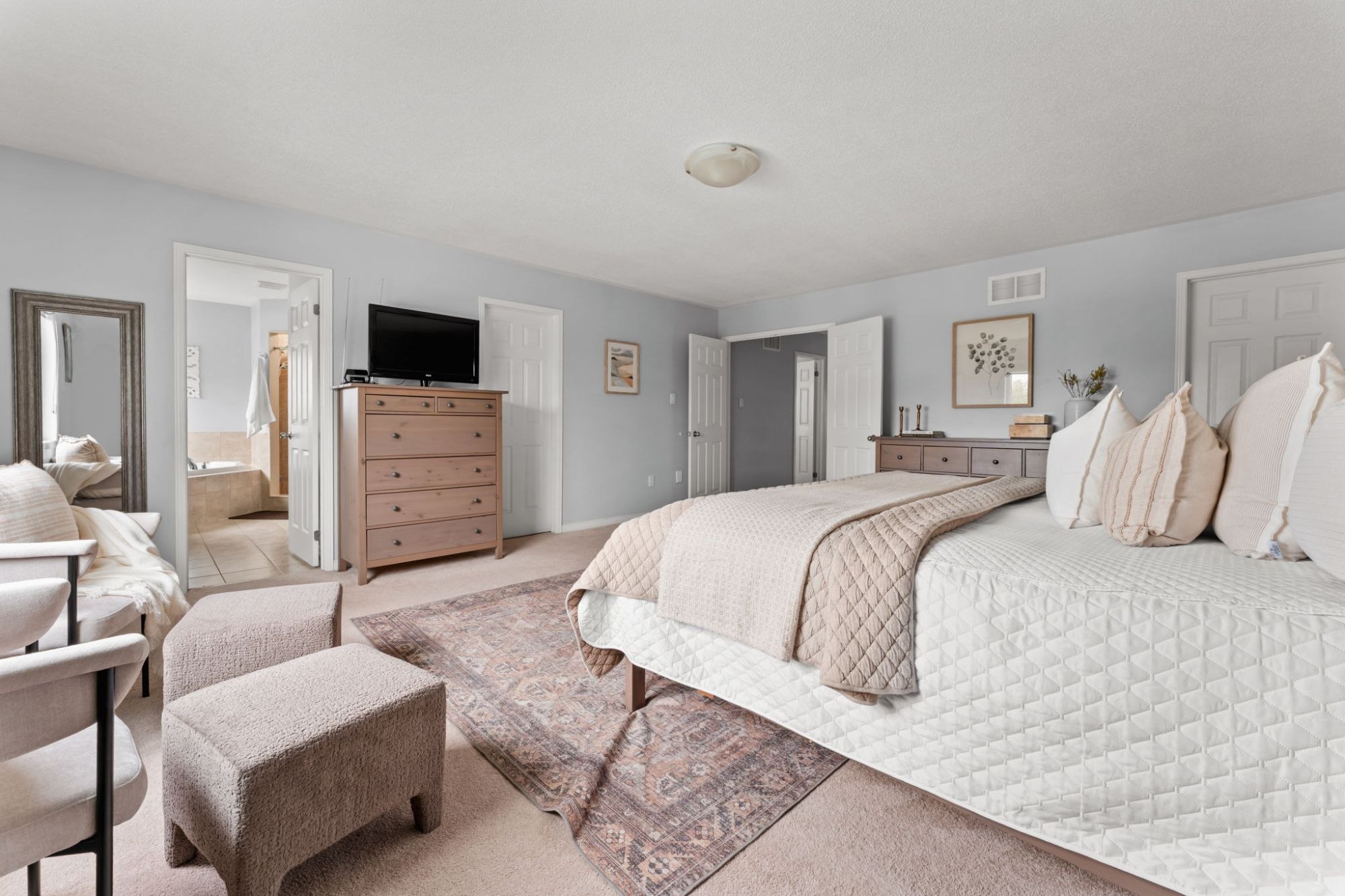 Wide view of the primary bedroom at 1683 Finkle Drive, Oshawa, showing the sitting area, dresser and ensuite doorway