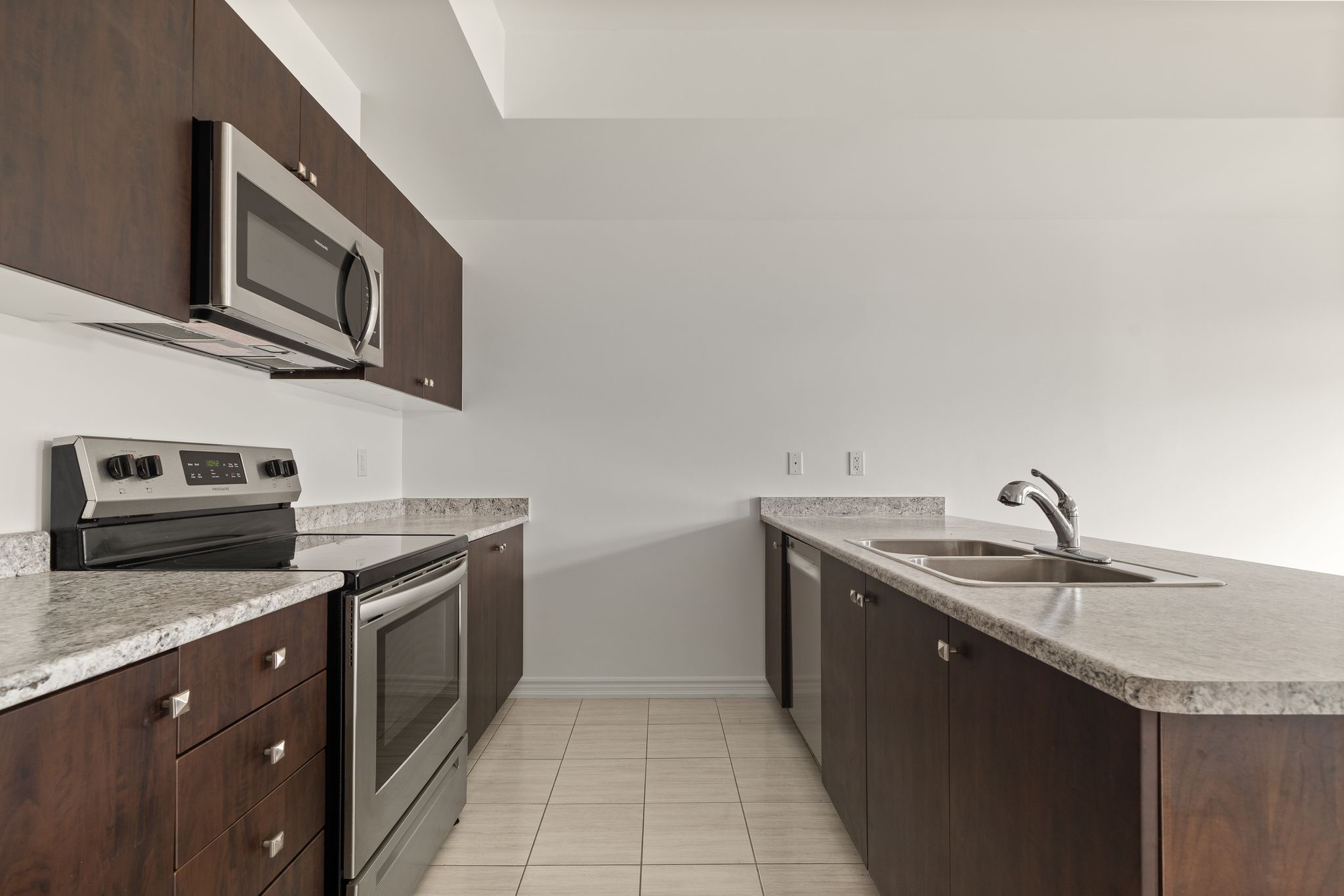 Kitchen at 2598 William Jackson Dr, Pickering, with dark wood cabinetry and a breakfast bar