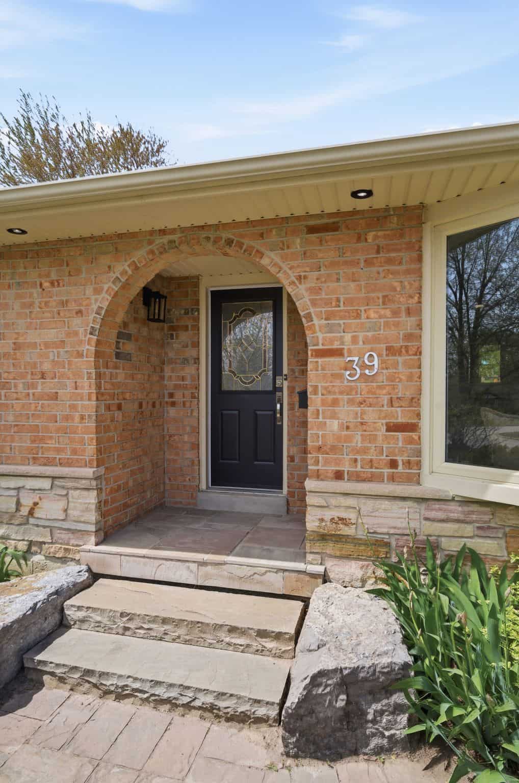 Arched brick front entry at 39 Anstead Crescent, South Ajax, with a black front door and stone steps