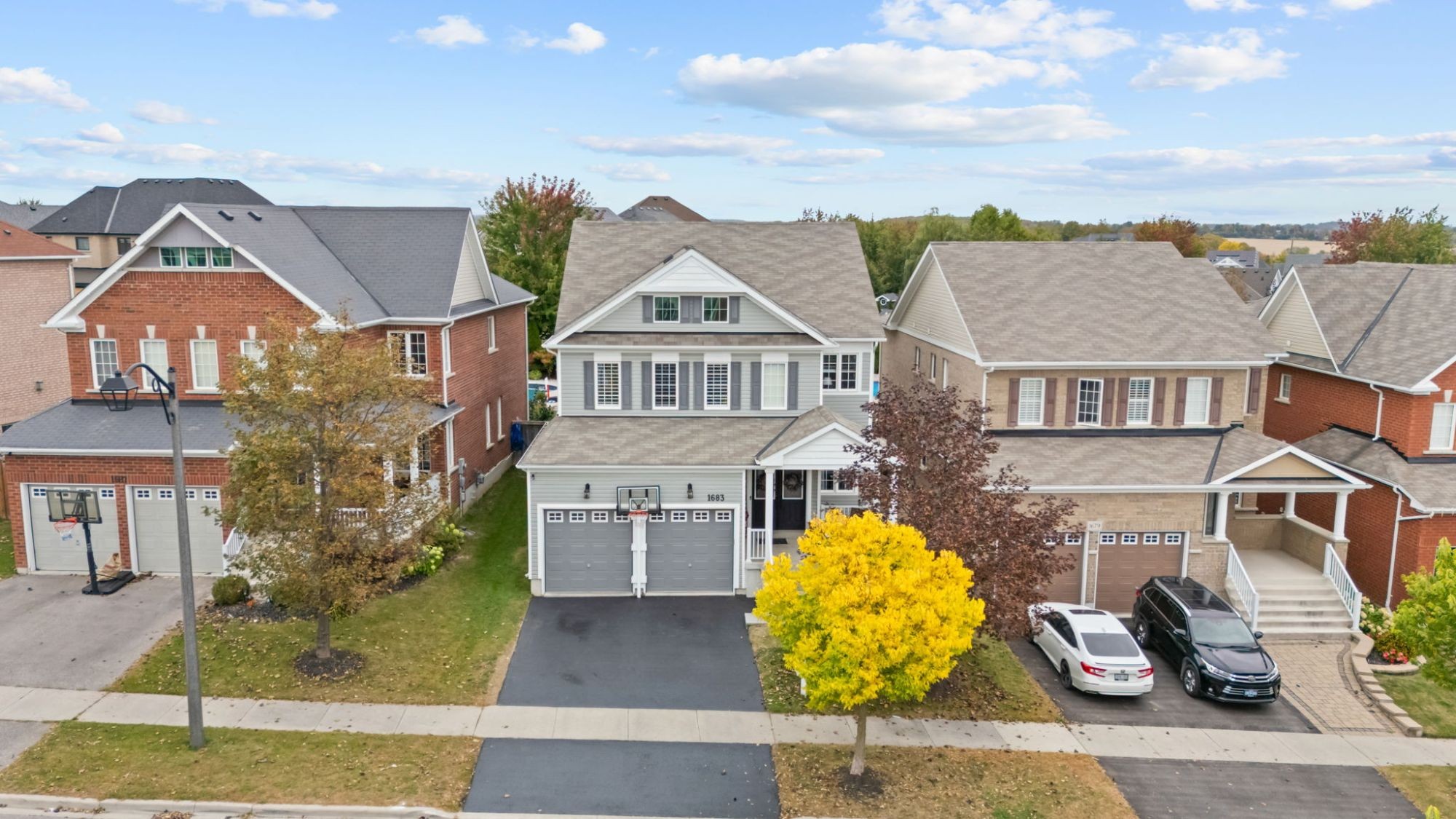 Aerial view of a two-storey detached home on a tree-lined street in Oshawa, Ontario