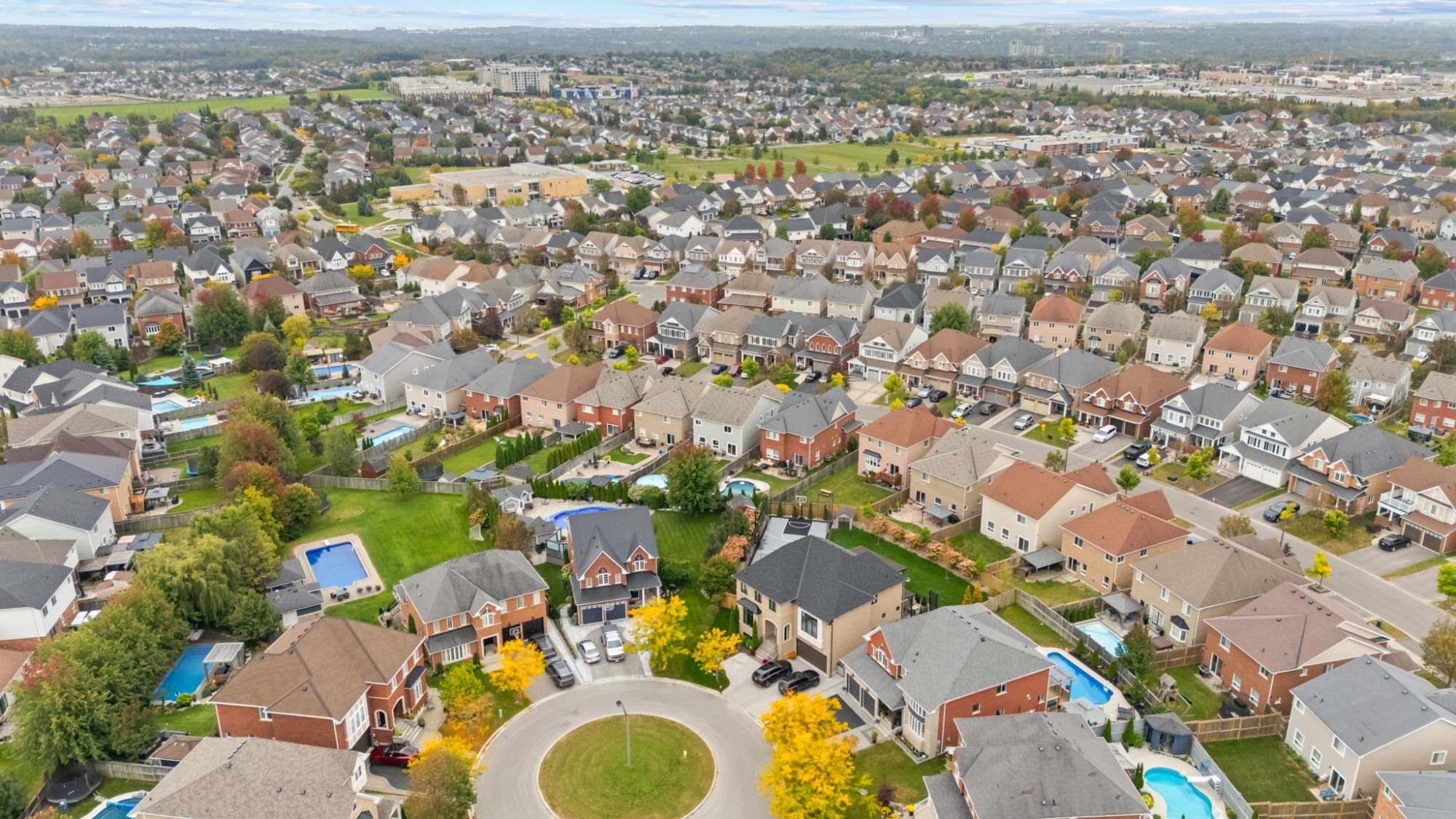 Aerial view of an established Oshawa subdivision with a cul-de-sac, pools and mature trees