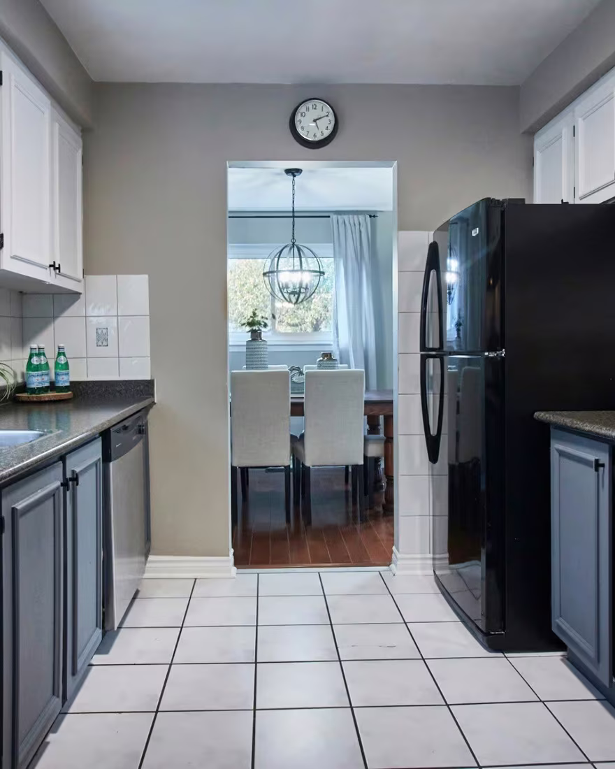 The same kitchen repainted white with updated hardware, after staging