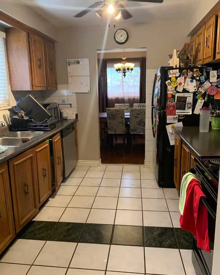 Kitchen with dated oak cabinets and a patterned floor runner, before staging